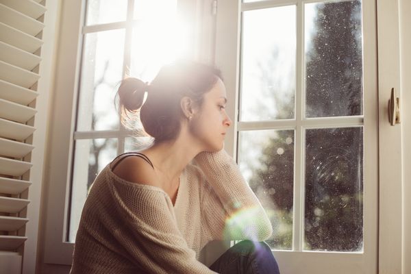 Unhappy woman sitting near the window