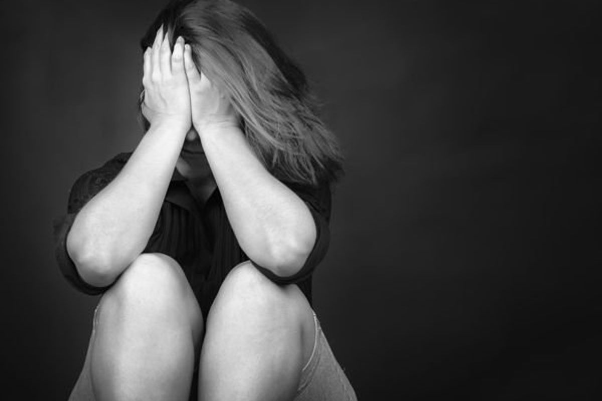 upset woman sitting with her head in her hands