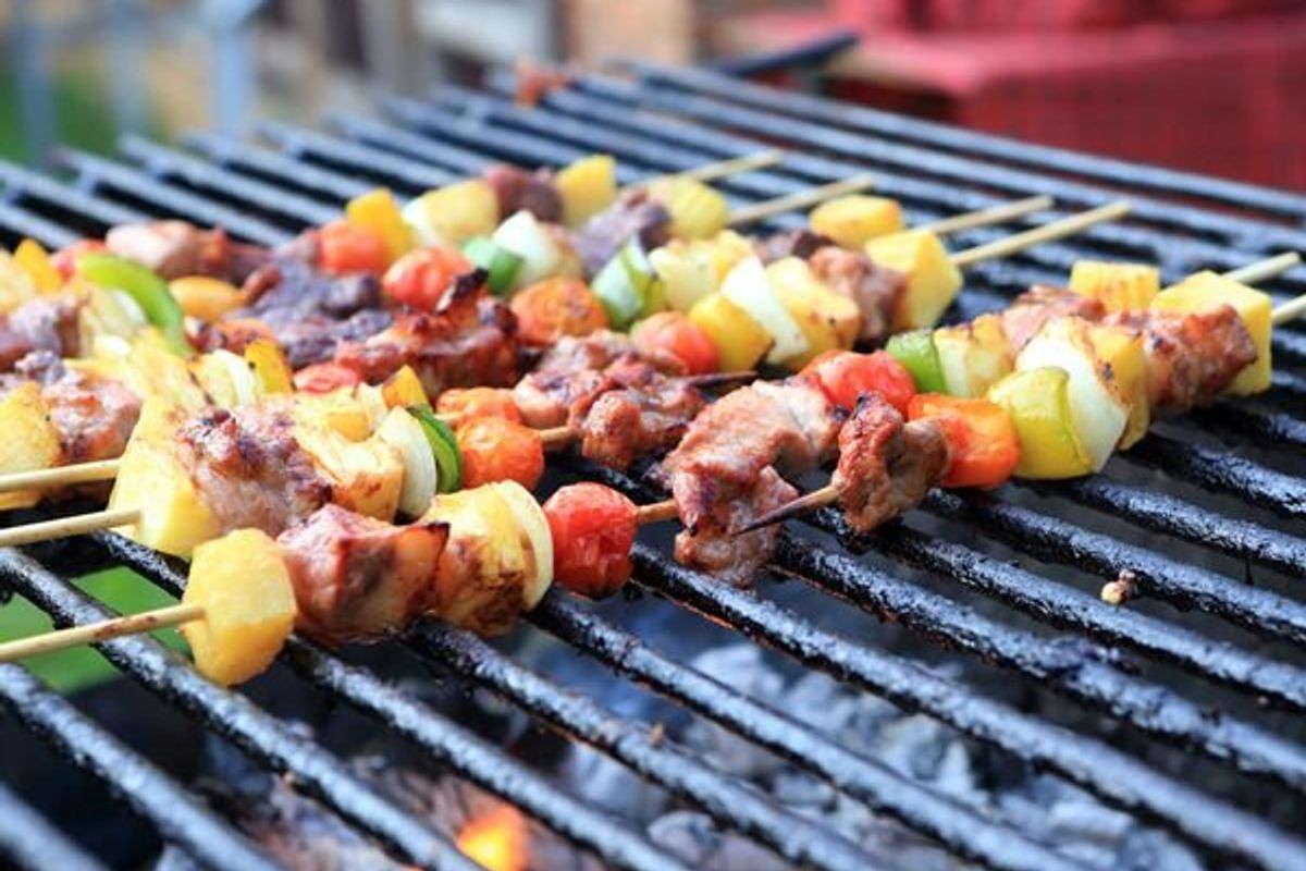 vegetable and meat kebabs cooking on the grill