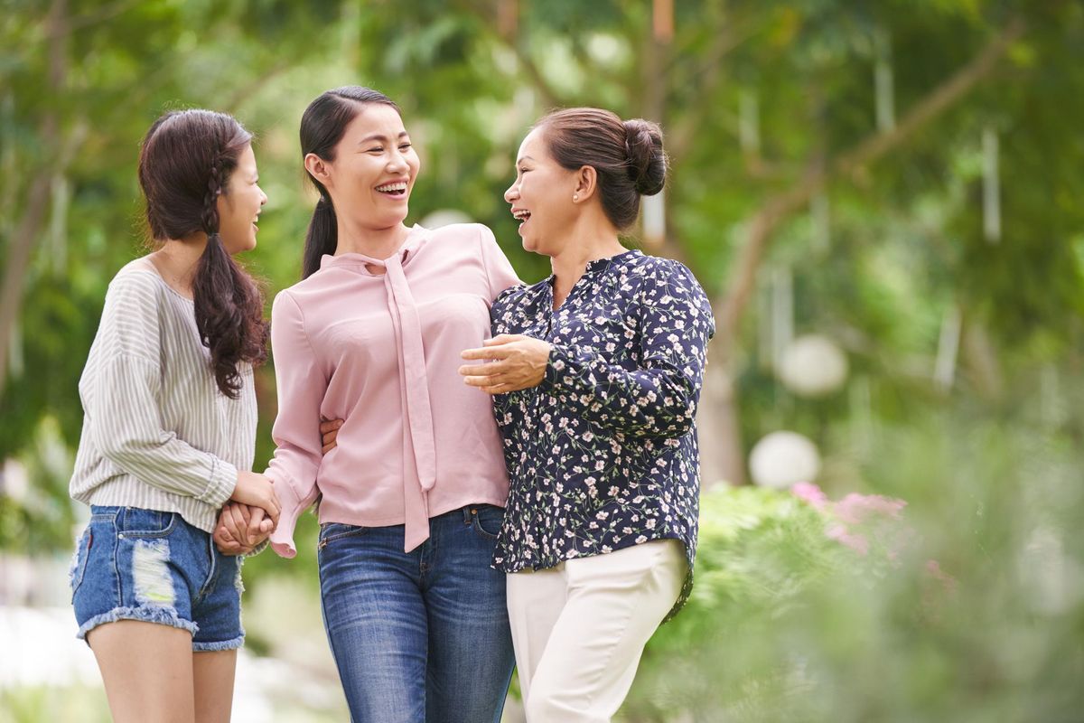 vietnamese teen girl with mother and grandmother walking outdoors and laughing