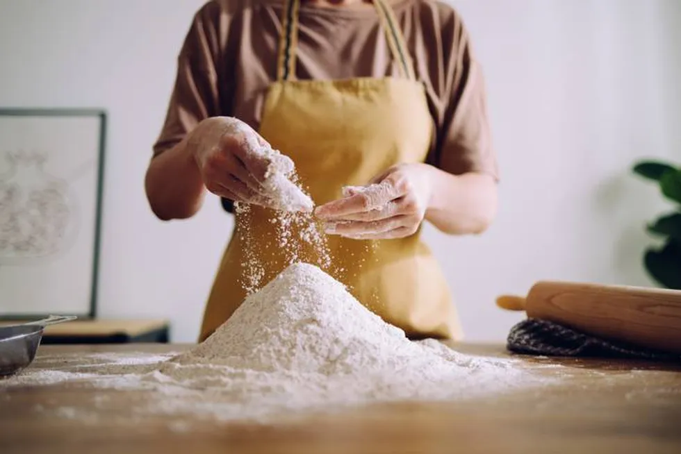 Woman Adding and Preparing Flour for Kneading