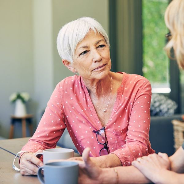 woman and her elderly mother having coffee and a chat at home