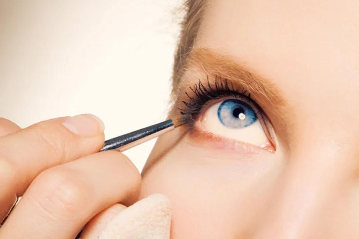 woman applying eyeliner