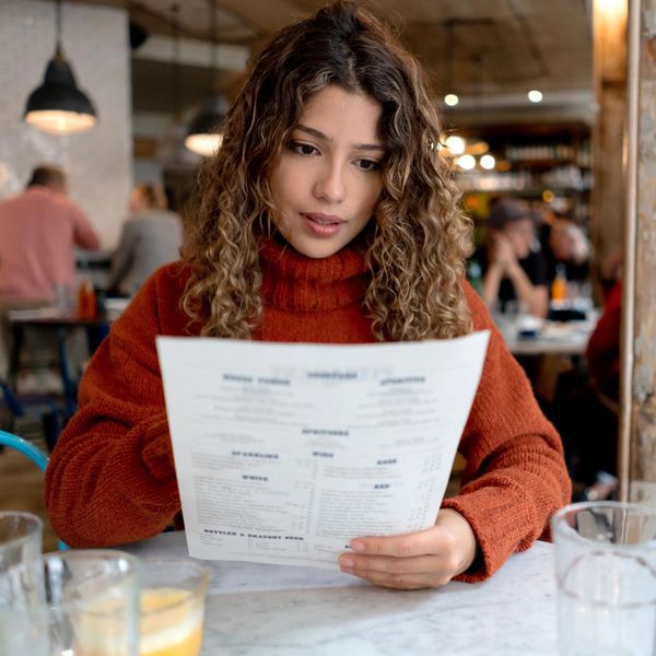 Woman at a restaurant reading the menu