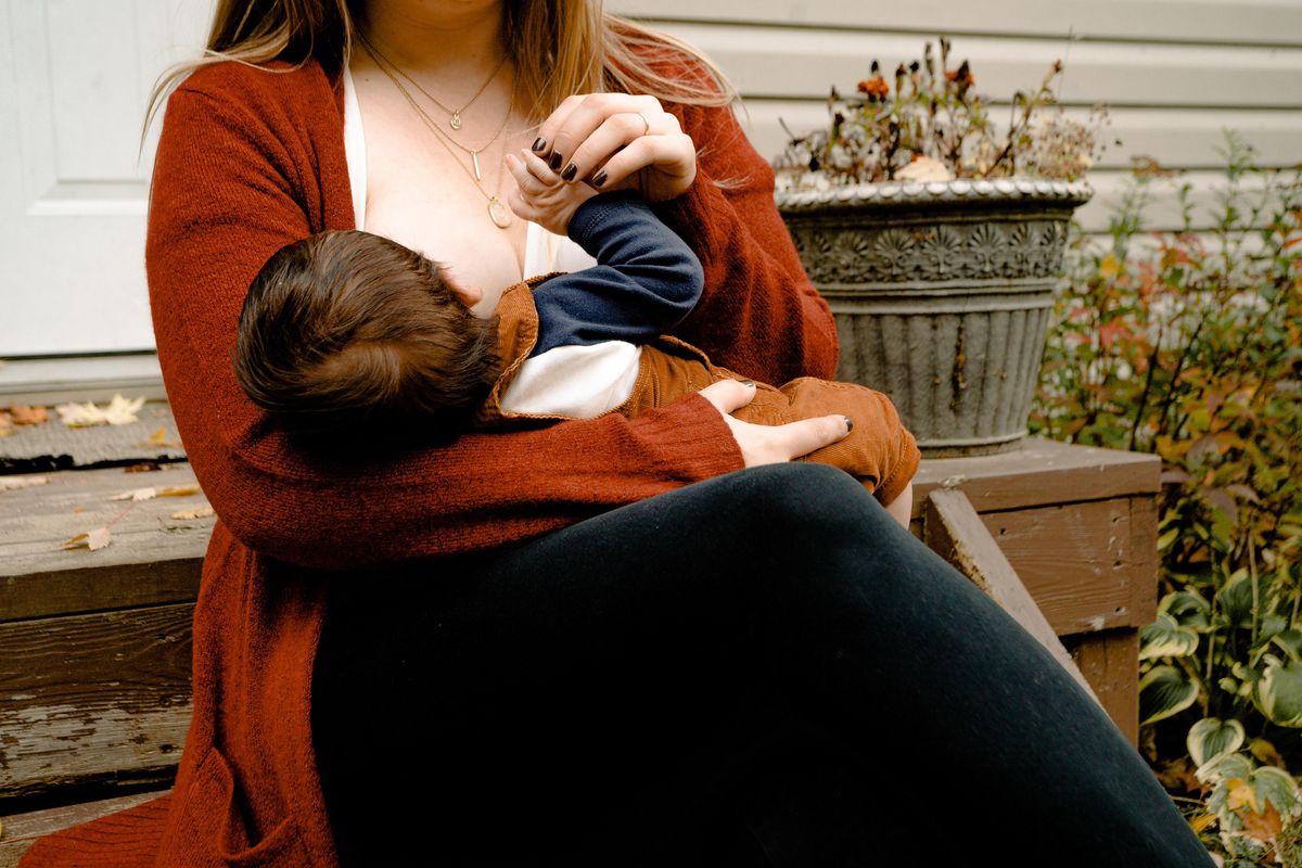 woman breastfeeding outside in Fall