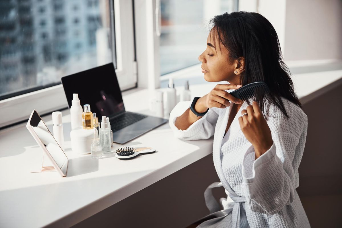 woman brushing hair at home