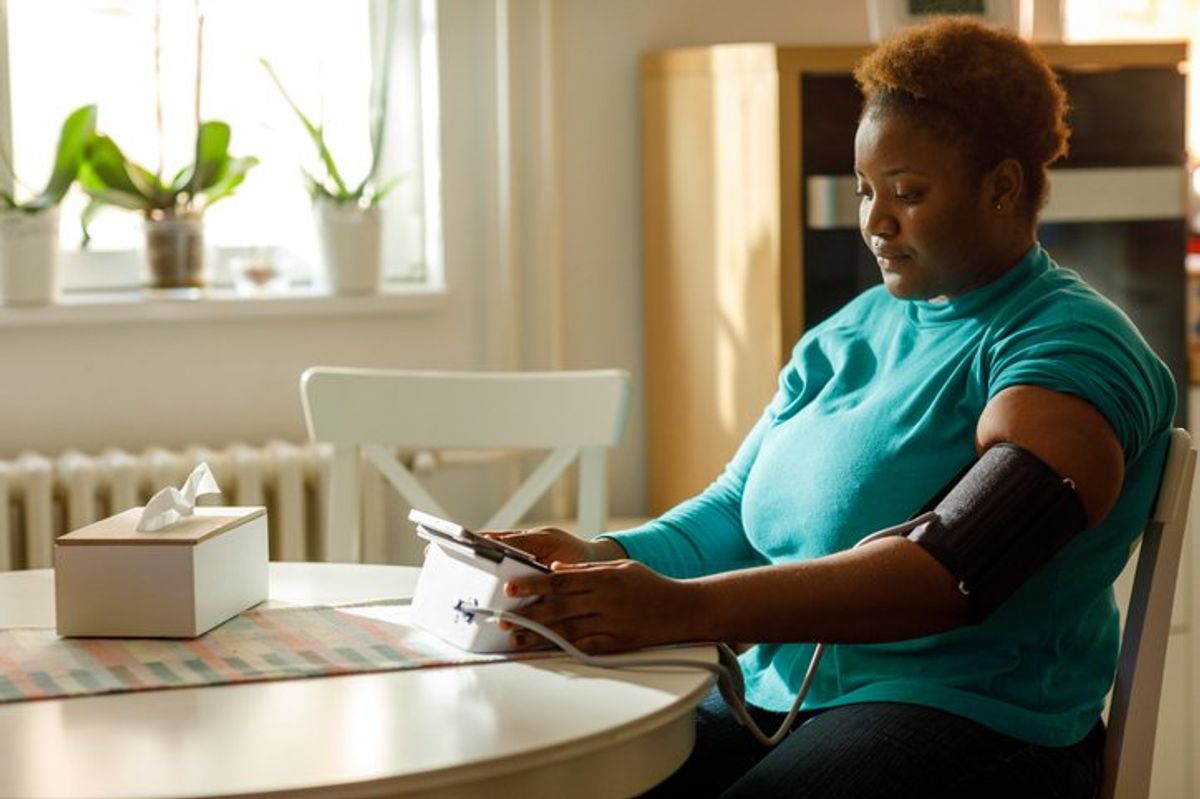 woman checks her blood pressure at home