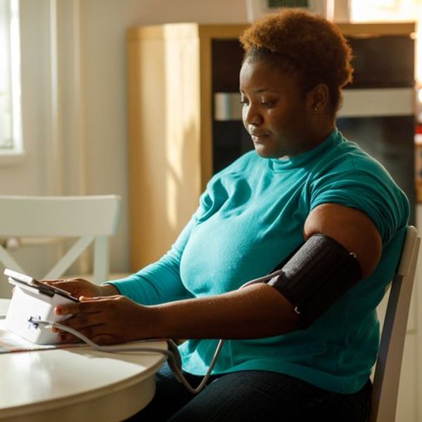 woman checks her blood pressure at home