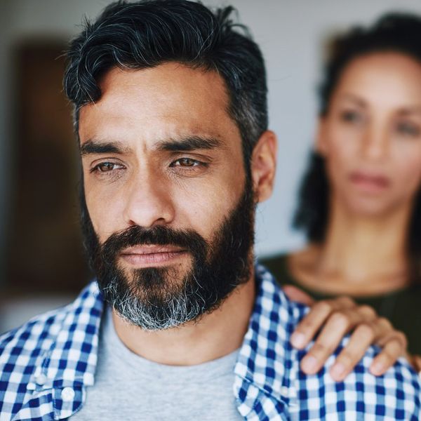 woman comforting her distraught husband at home