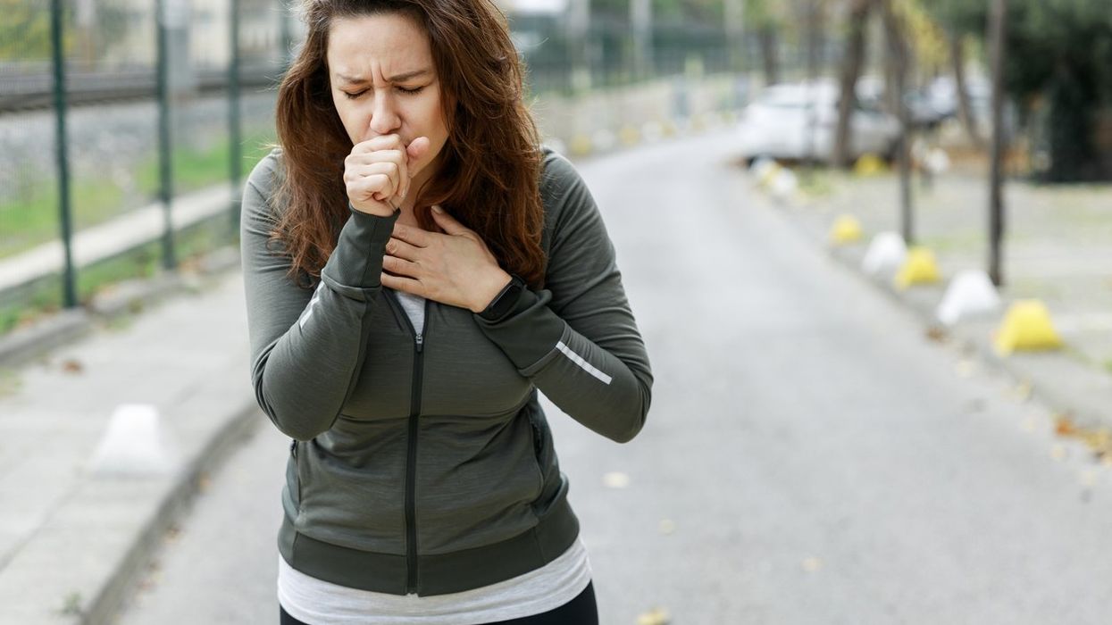 woman coughing while walking