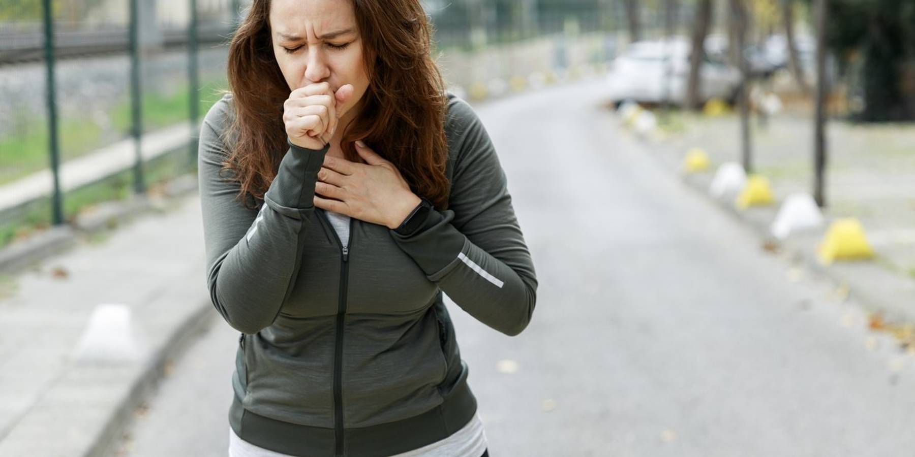 woman coughing while walking