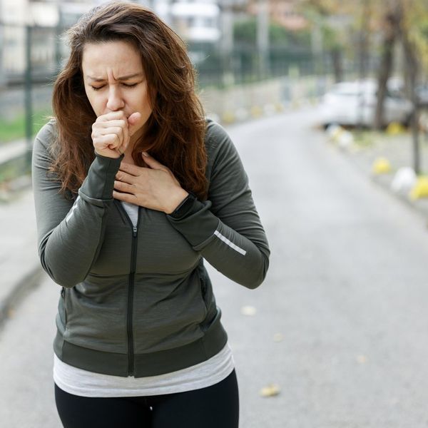 woman coughing while walking