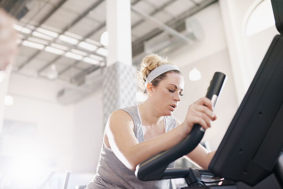 woman doing a High-Intensity Workout on an exercise bike in a gym