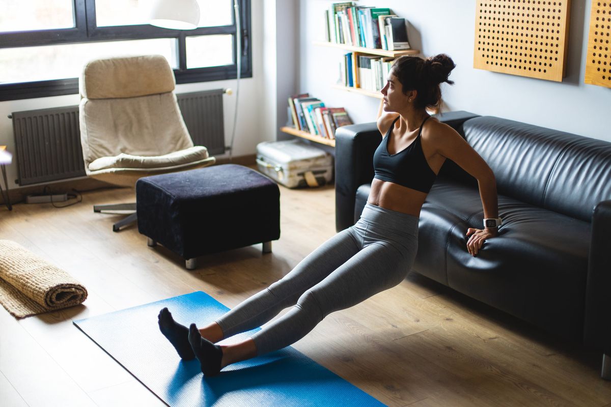 woman doing triceps dips exercise in the living room