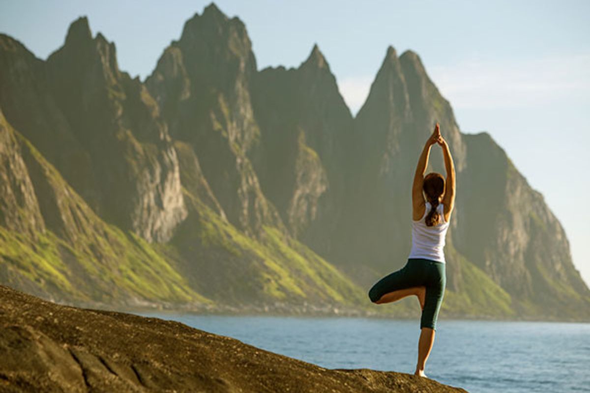 woman doing yoga looking at mountains