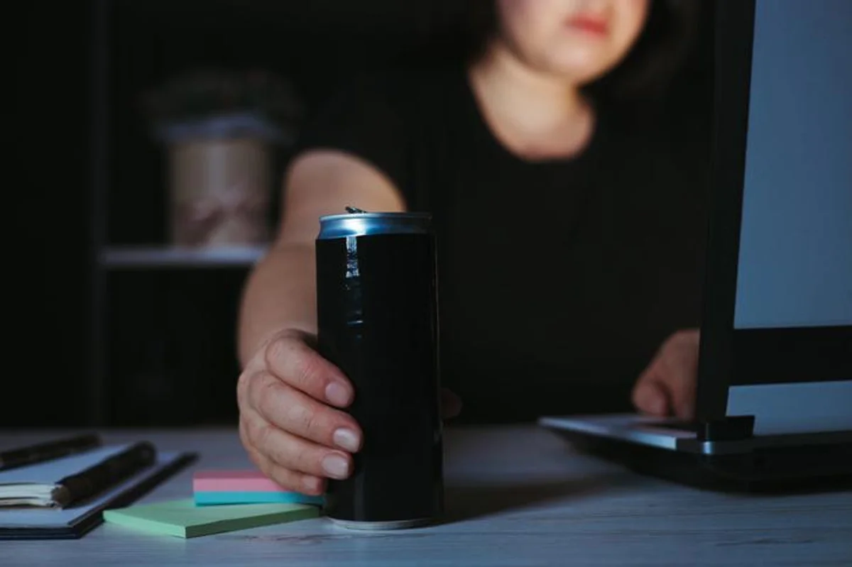woman drinking energy drink at night