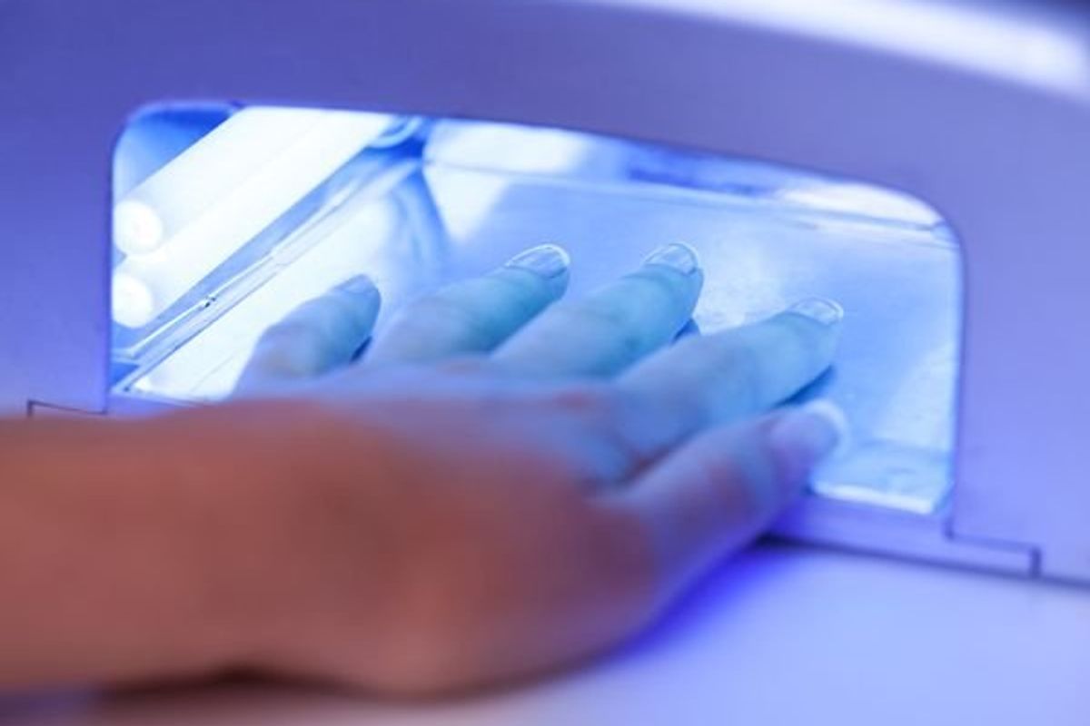 woman drying her nails in a UV light