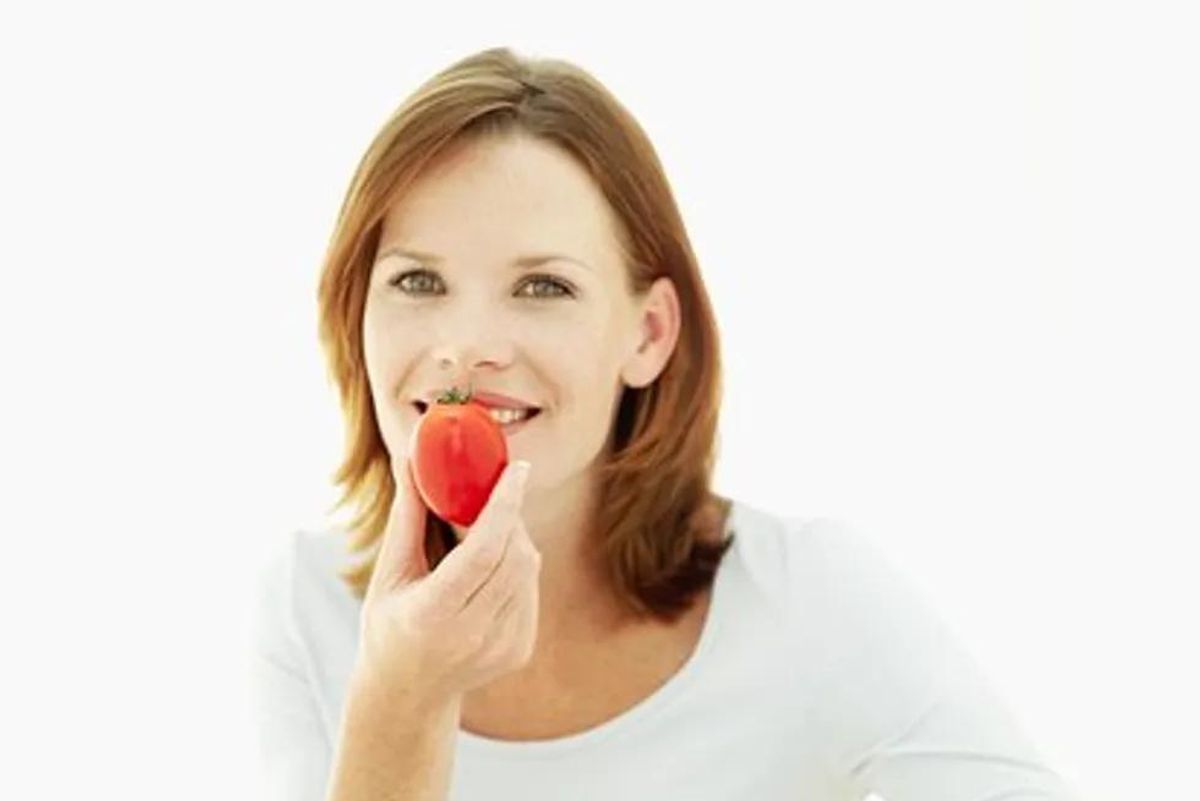 woman eating a tomato