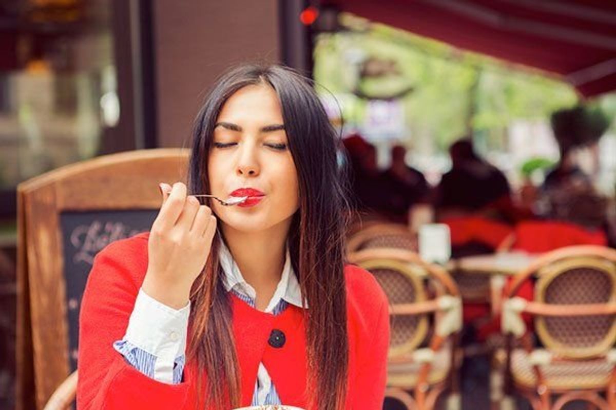 woman eating a yogurt at a cafe