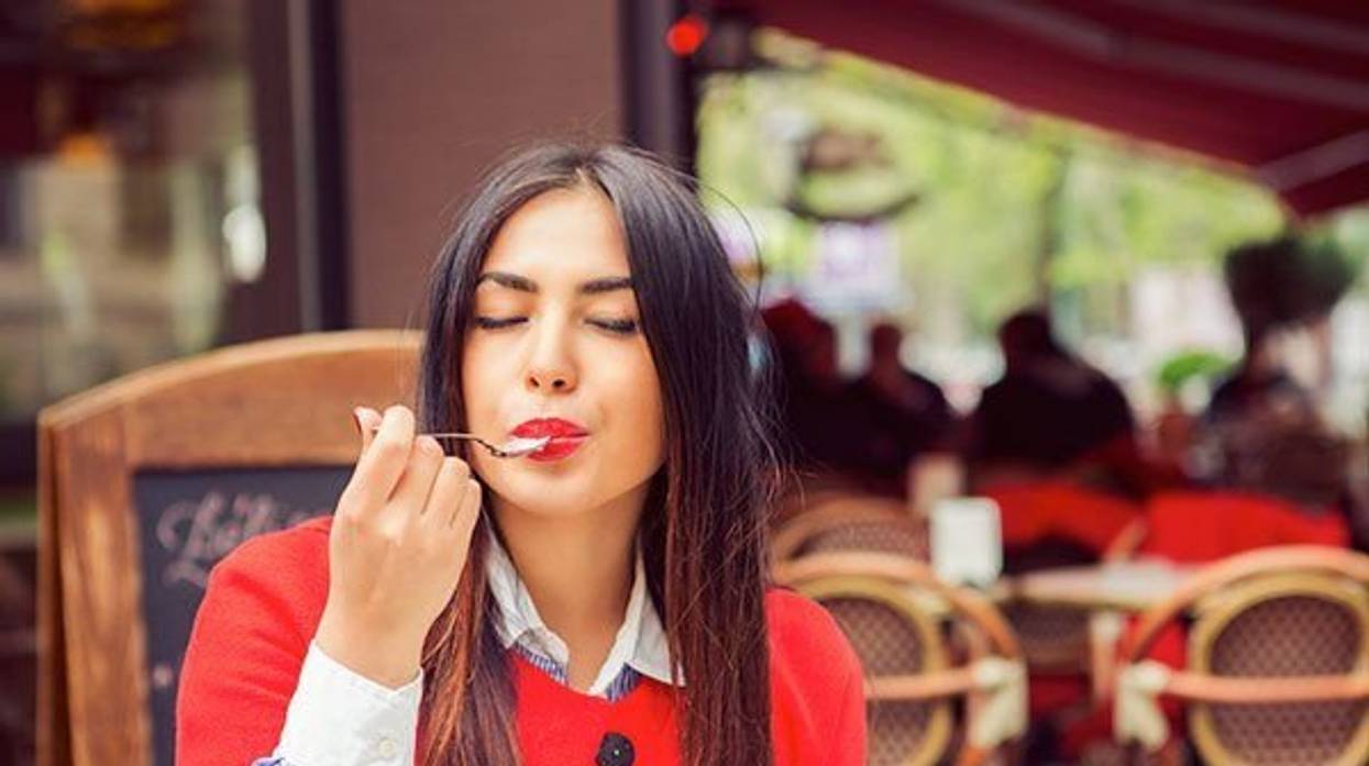 woman eating a yogurt at a cafe