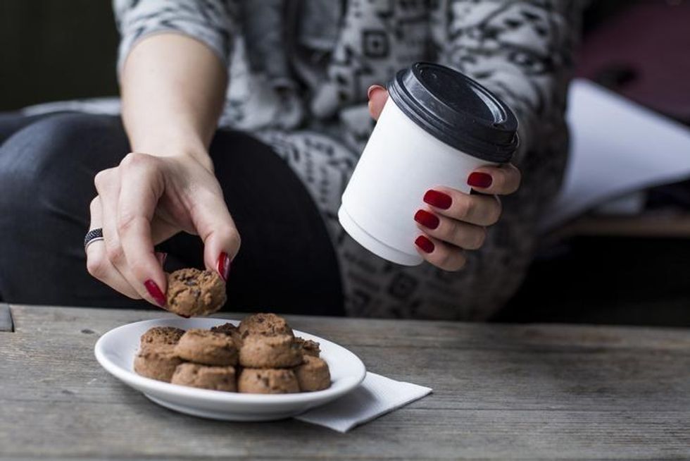 woman eating cookies with coffee