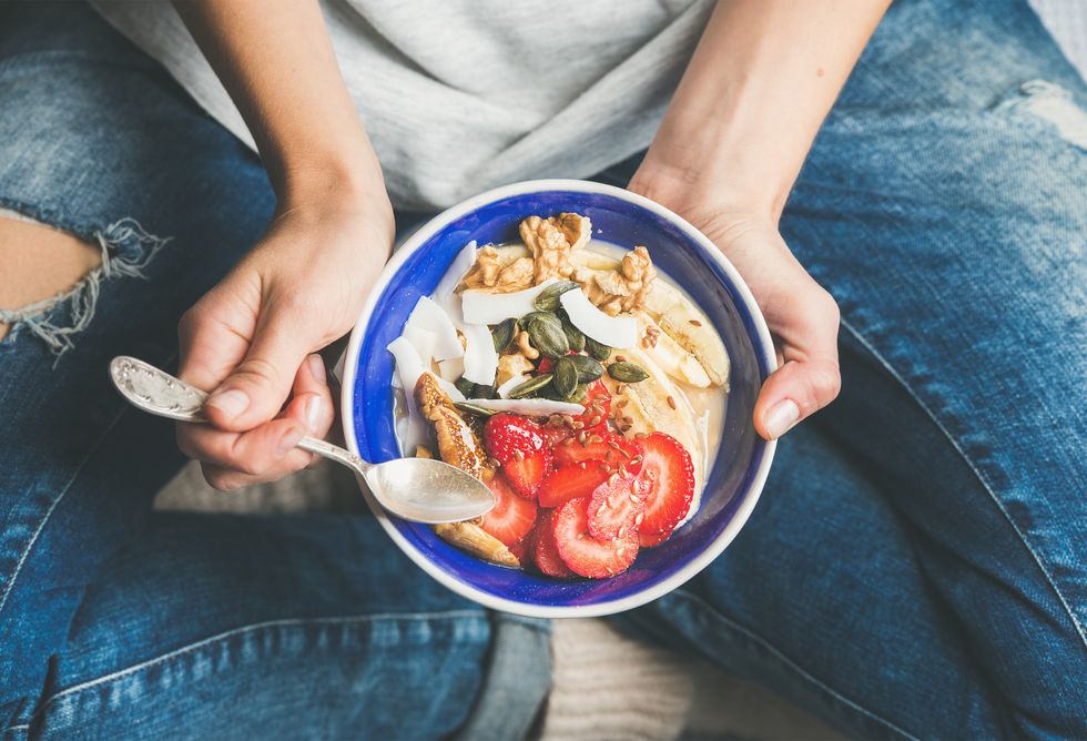 woman Eating healthy breakfast bowl to help lower her cholesterol