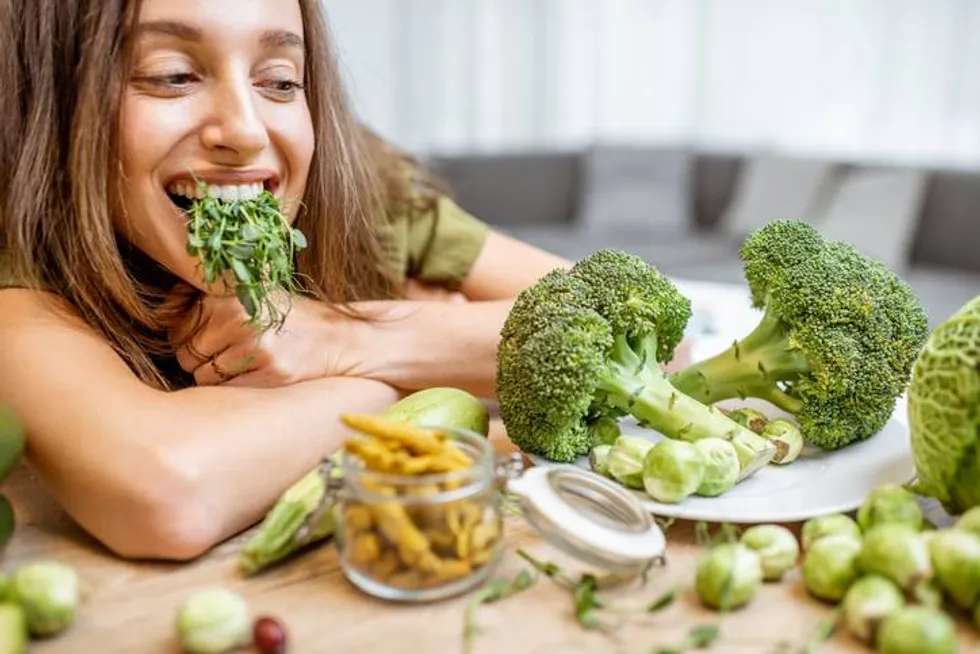 woman eating raw green vegetables - fibermaxxing