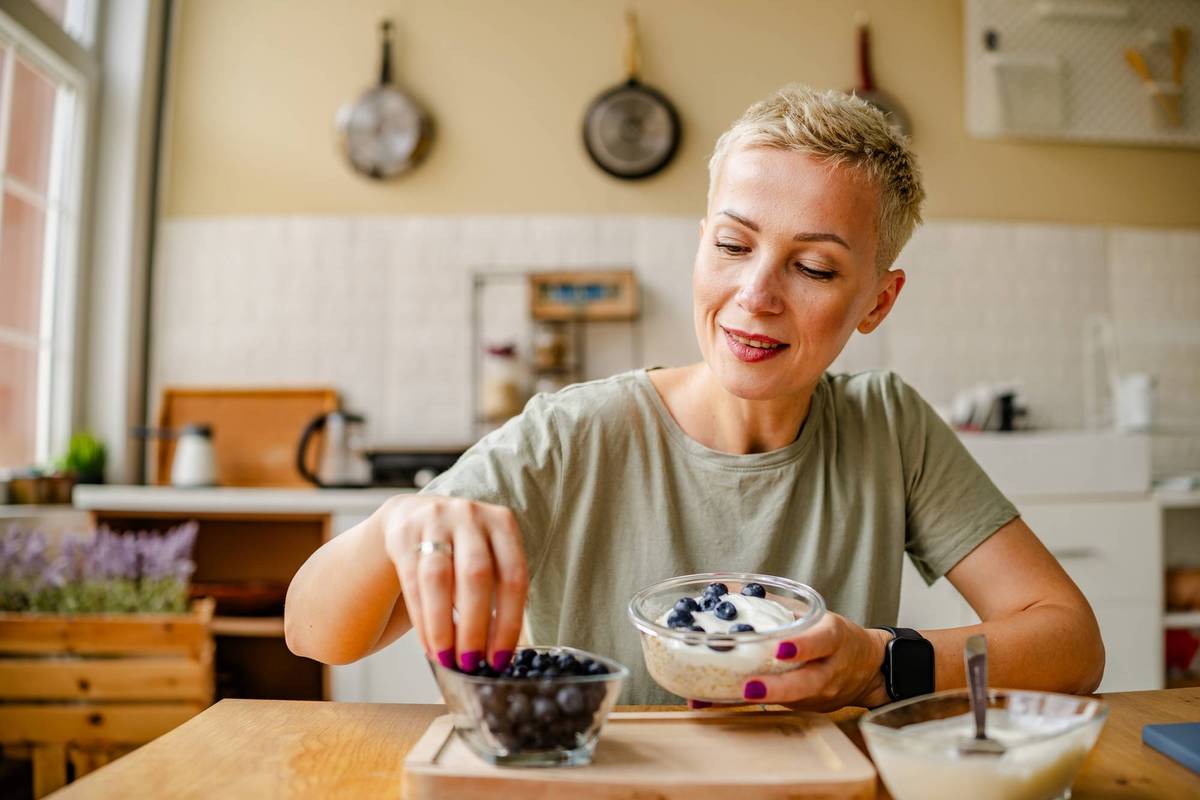 Woman enjoys a healthy snack of fresh blueberries