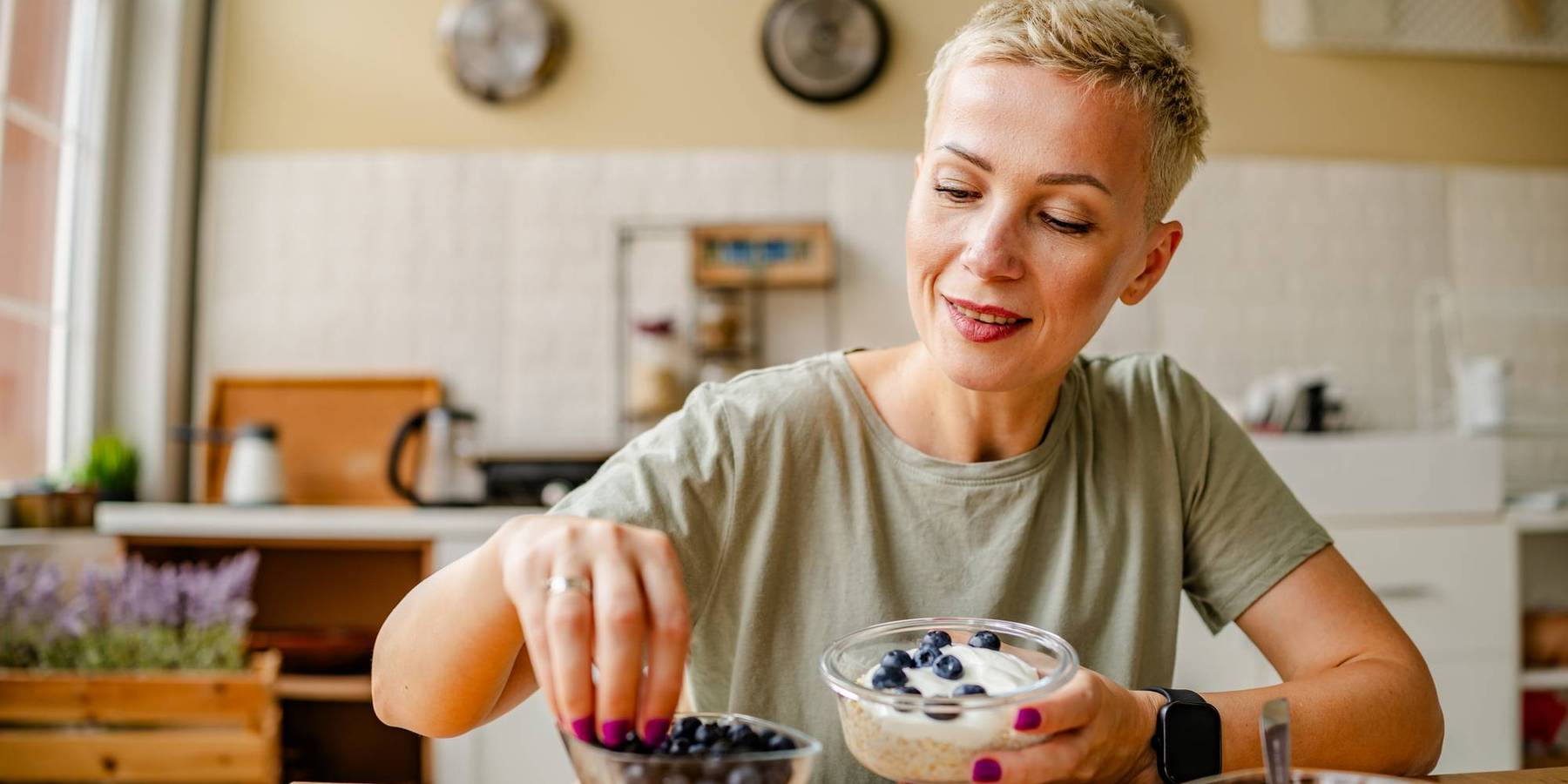 Woman enjoys a healthy snack of fresh blueberries