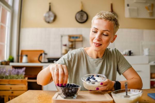 Woman enjoys a healthy snack of fresh blueberries