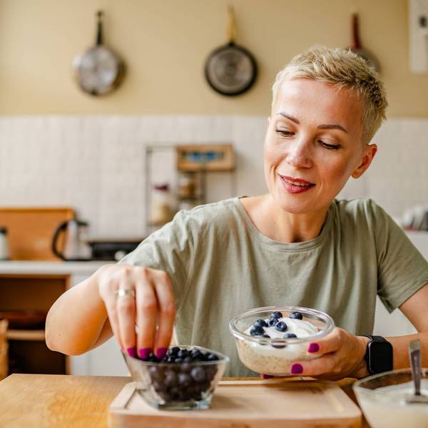 Woman enjoys a healthy snack of fresh blueberries