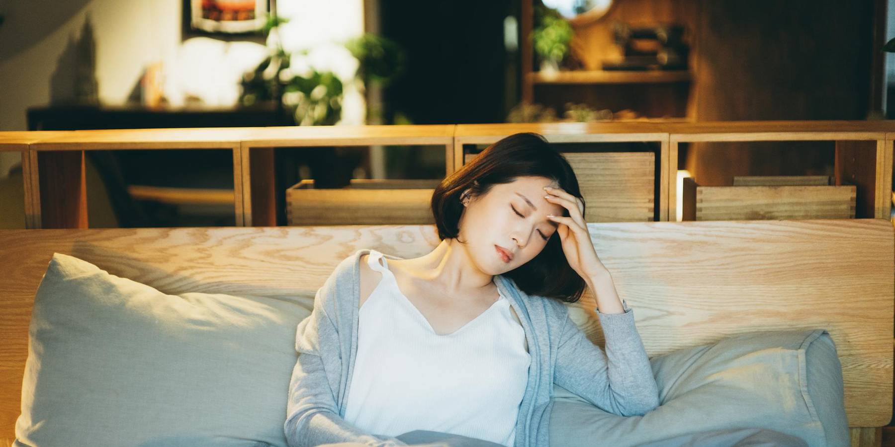 woman feeling sick and suffering from a Iron Deficiency Anemia, lying on the bed