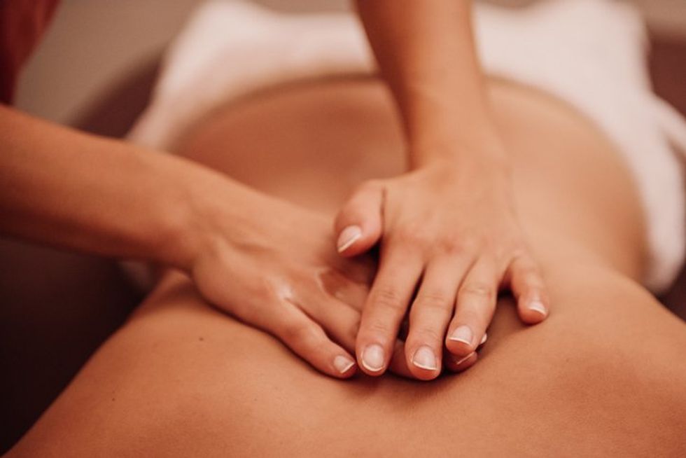 woman getting a back massage at a spa