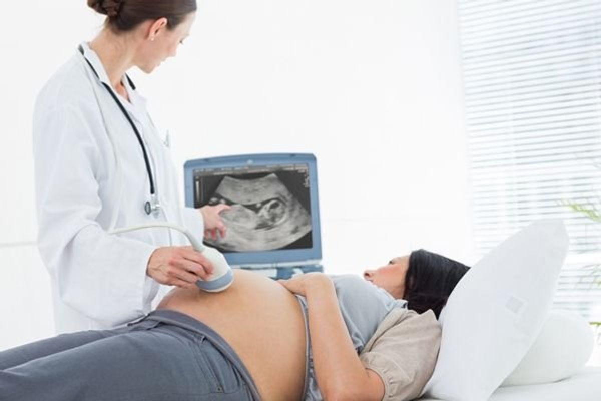 woman getting an ultrasound on her pregnant stomach