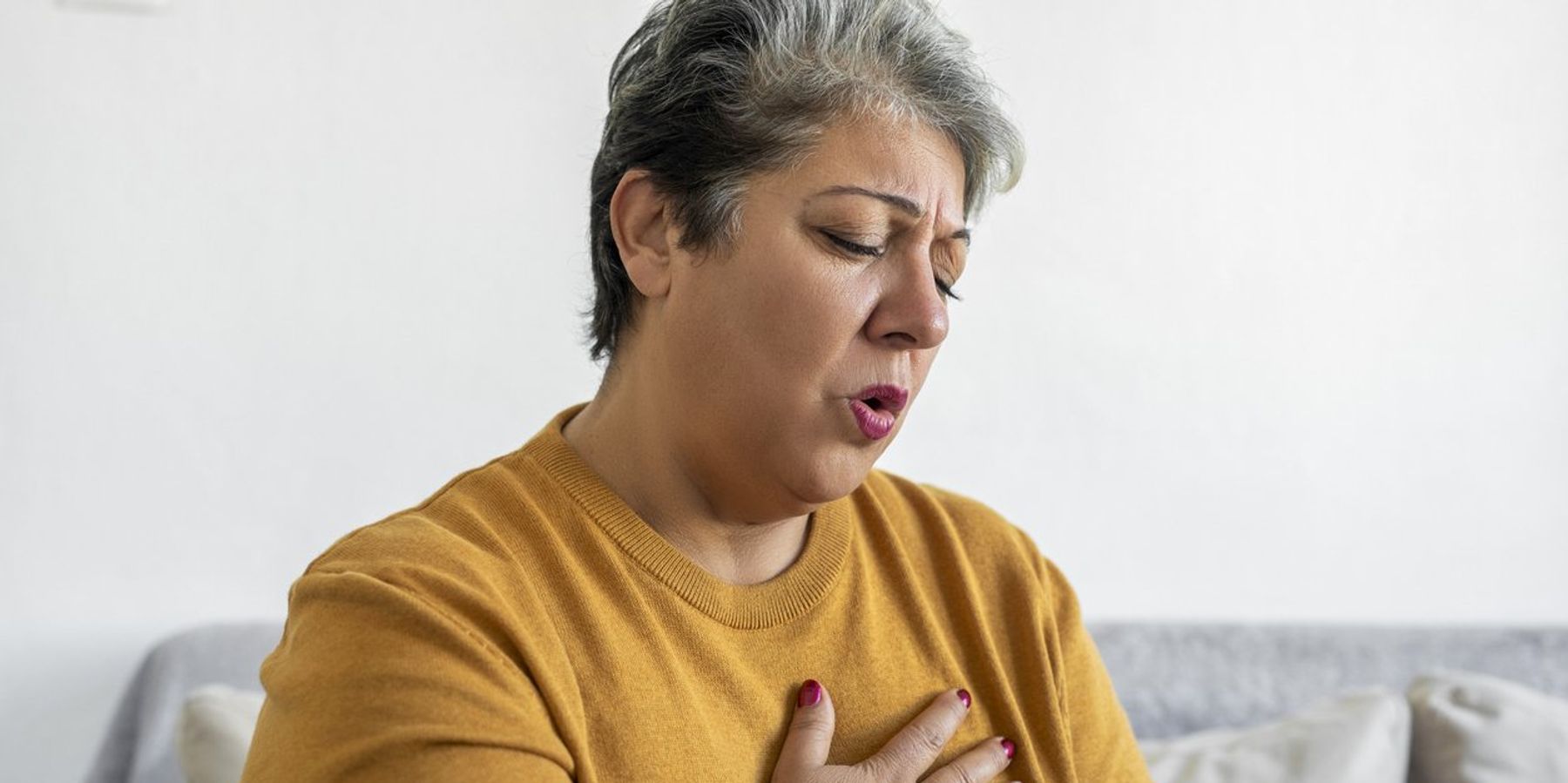 Woman hand holding chest pain, difficulty to breathe