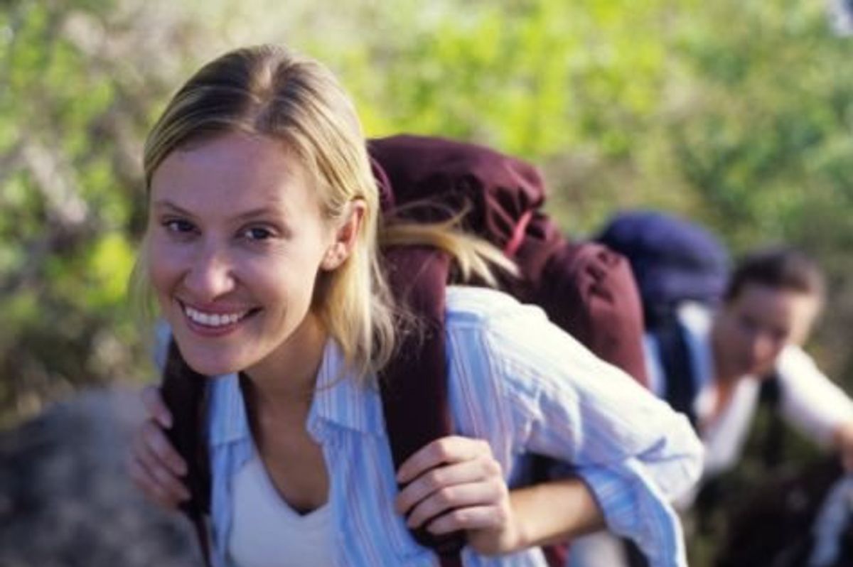 woman hiking with a backpack on to improve endurance