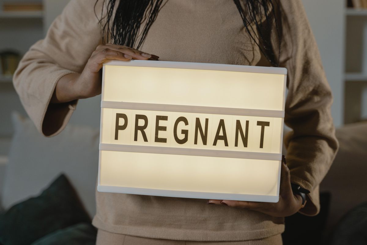 Woman Holding A Box With Pregnant Text