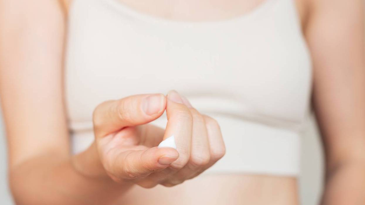 Woman holding a drop of white moisturizing cream on her finger