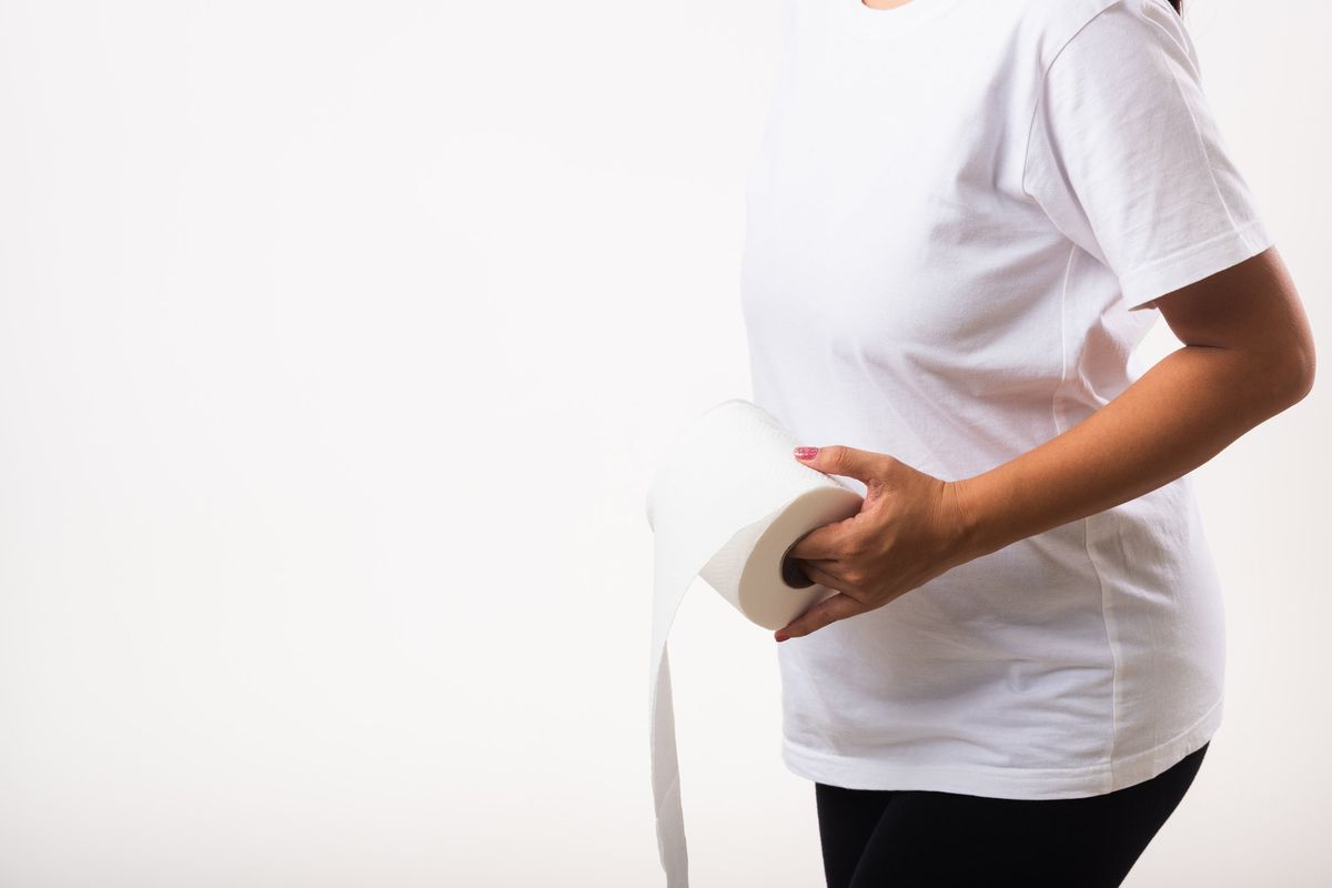 woman holding a roll of toilet paper