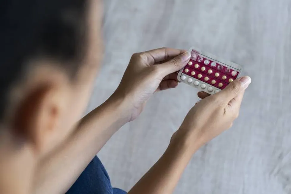 woman holding birth control pills