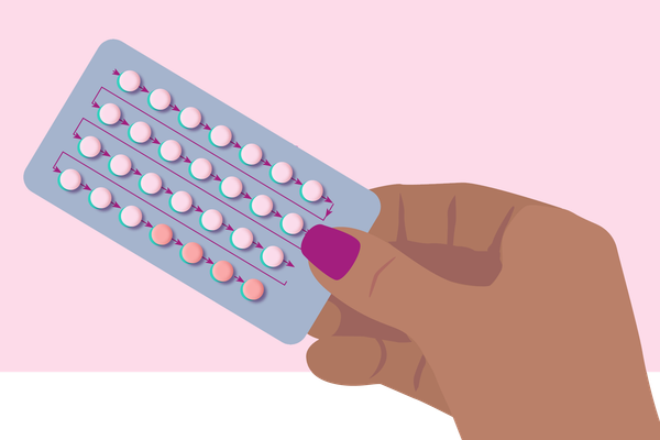 woman holding birth control pills