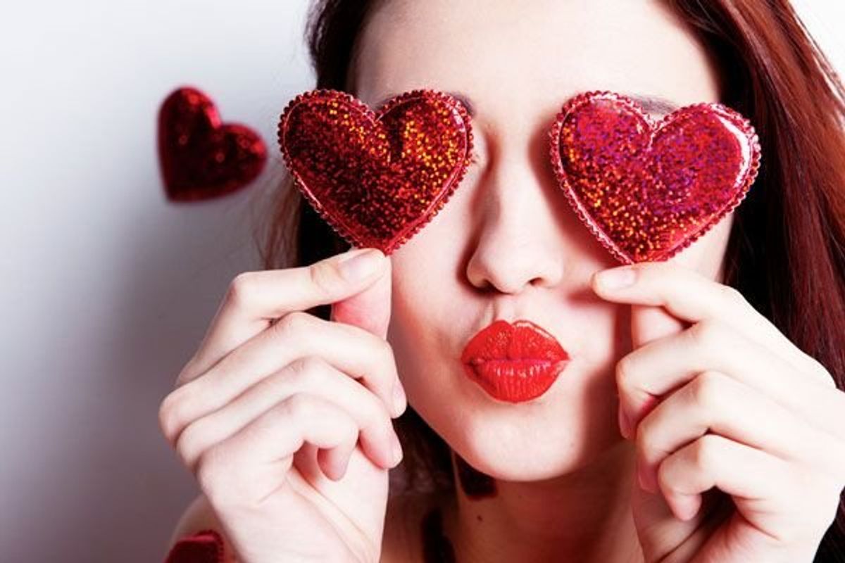 woman holding hearts over her eyes