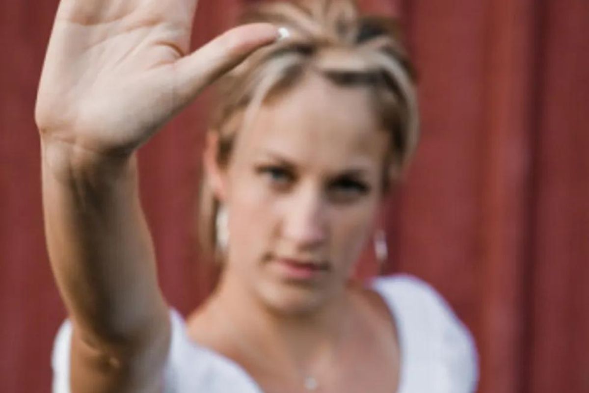 woman holding her hand out as if to say stop