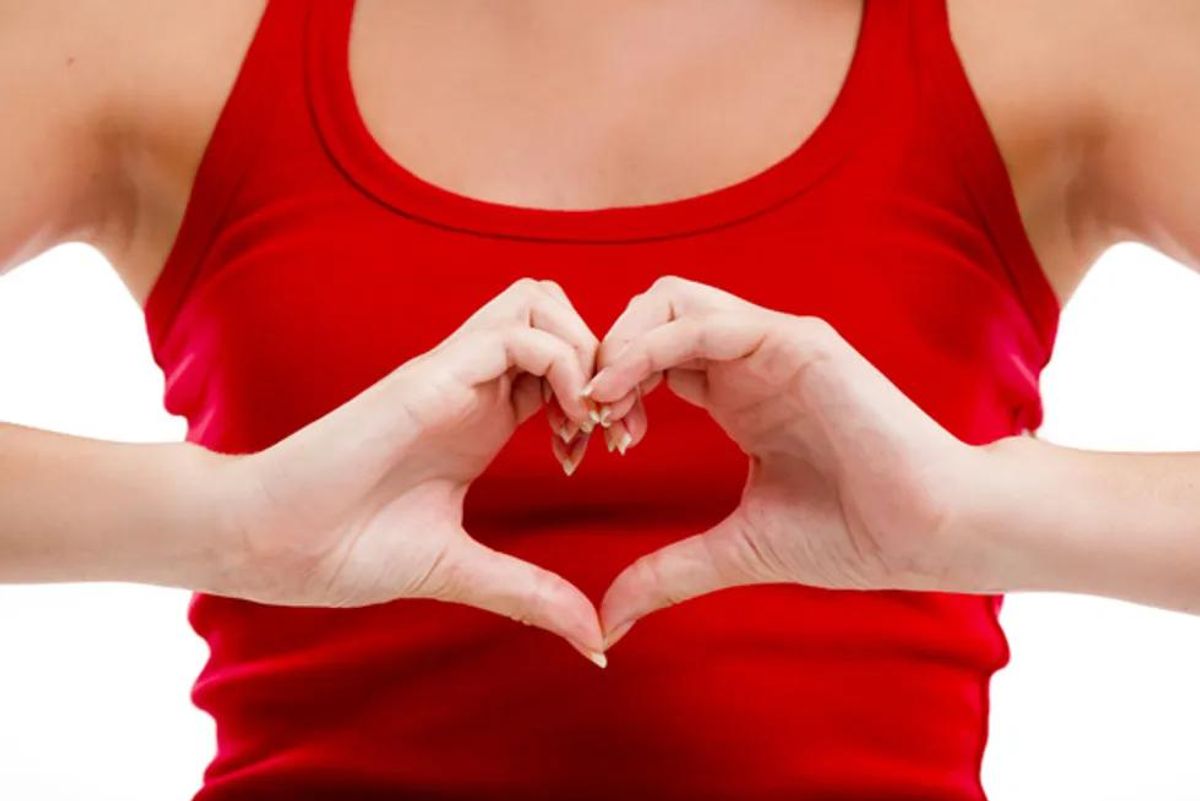 woman holding her hands in the shape of a heart