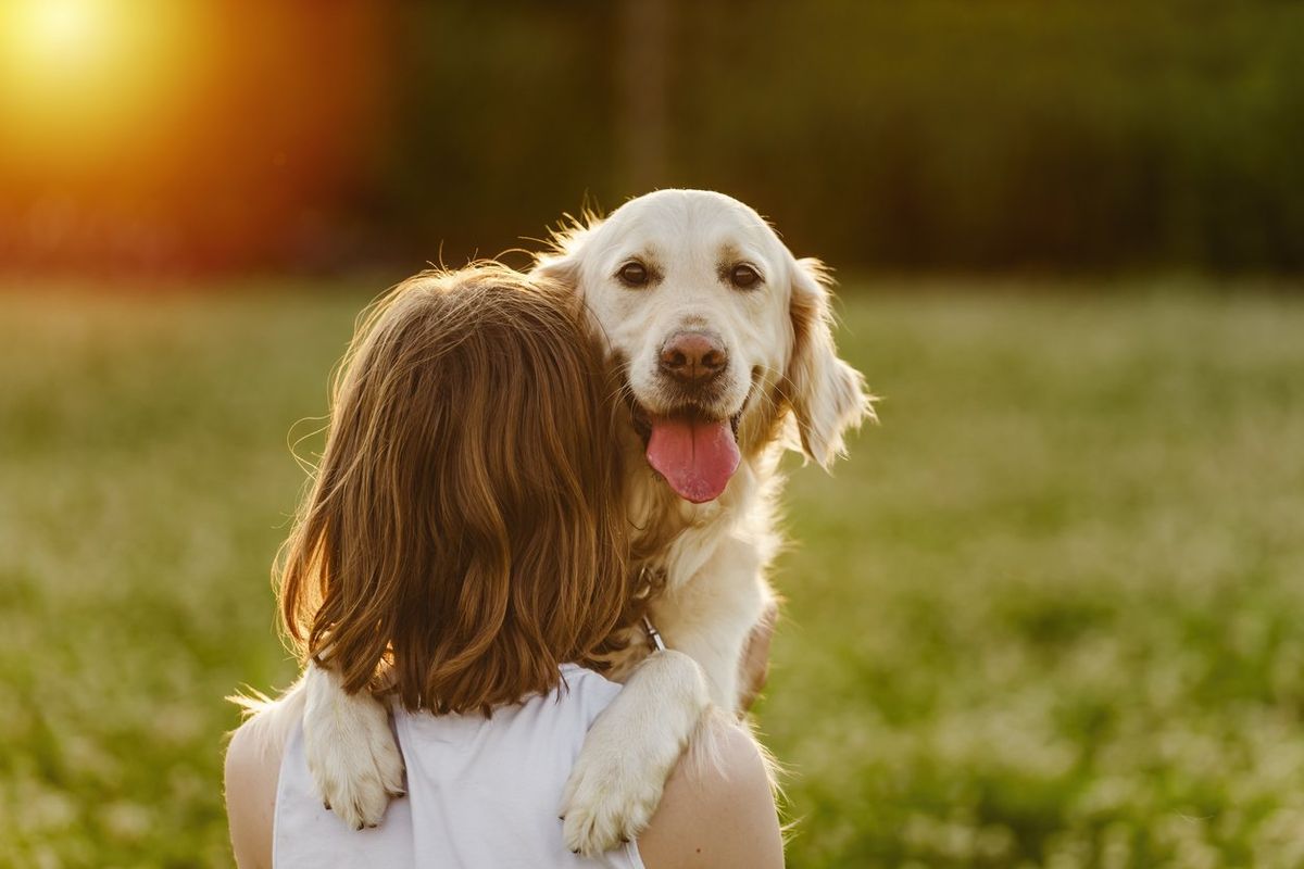 woman hugging her dog outside