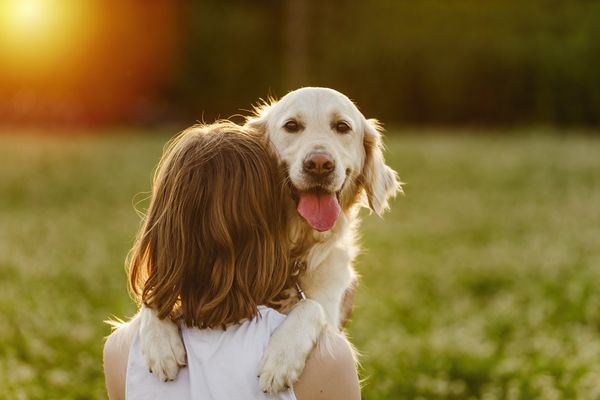 woman hugging her dog outside