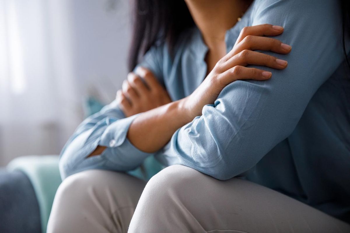 woman hugging herself to comfort while sad