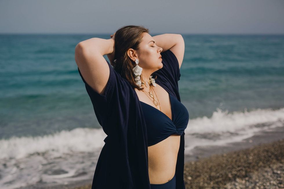 woman in a blue swimsuit resting on the beach