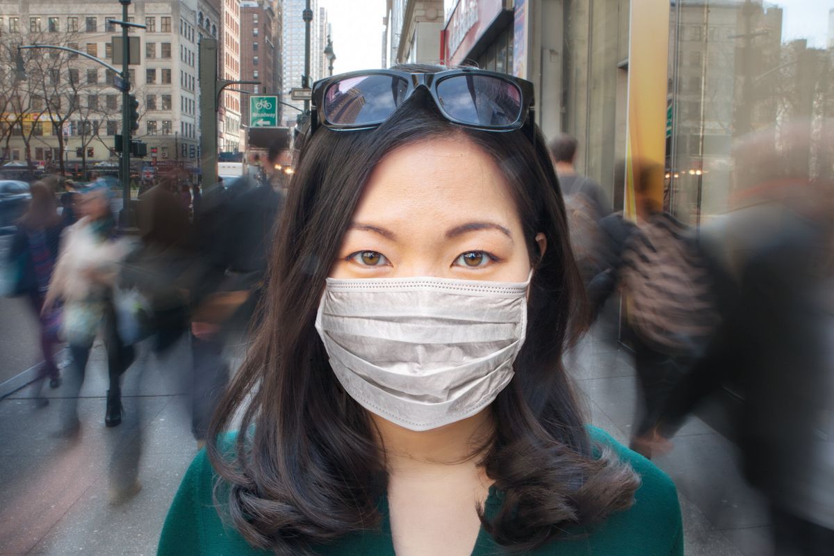 Woman in crowd wearing surgical mask