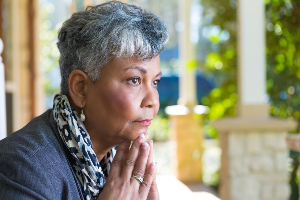 woman in deep thought on her front porch.